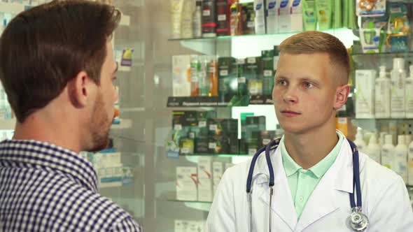 Doctor Listening To Patient in Drugstore