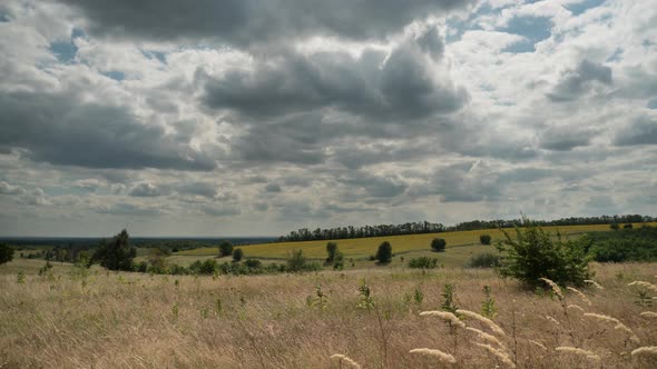 Landscape Dramatic Fields and Moving Storm Clouds in Blue Sky. Timelapse. Amazing Rural Valley