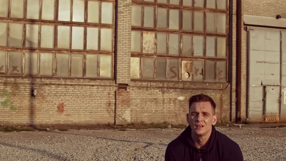 Young and fit man having evening workout outdoor. Urban sunset background.