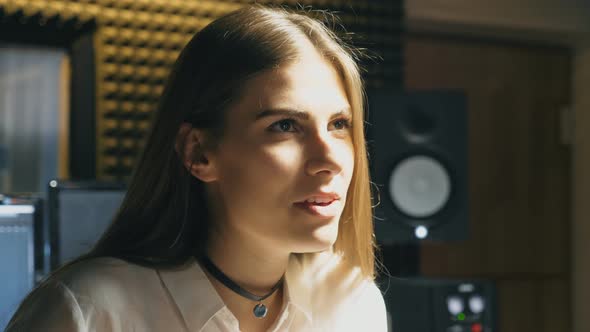 Portrait of Beautiful Girl Singing in Sound Studio