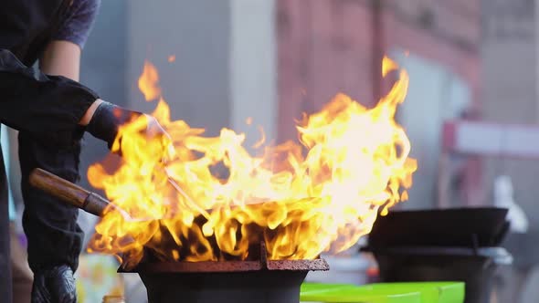 Chef Cooking Thai Food In Wok On Burner With Fire Flame Closeup
