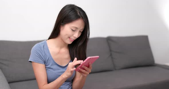 Woman working on cellphone at home