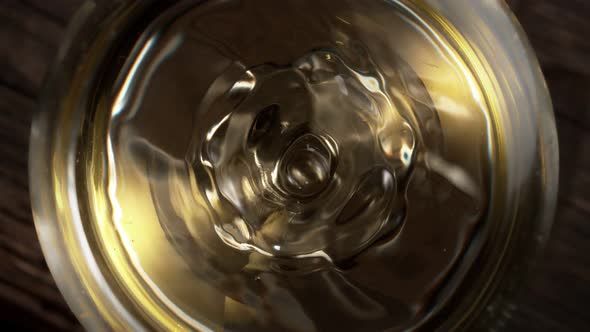 Super Slow Motion Macro Shot of Dripping Droplet Into Filled Glass of White Wine at 1000Fps