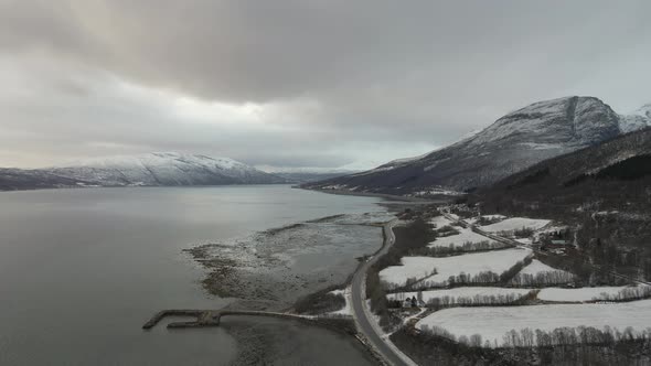 Freezing cold Norwegian Arctic landscape, drone view of fjord and snowy mountains