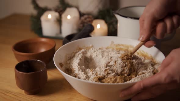 A Woman Rolls Out a Lump of Dough with a Rolling Pin