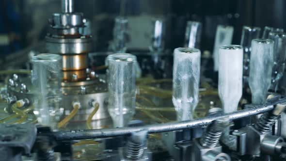 Glass Bottles Are Getting Washed From Inside While Rotating Along the Conveyor