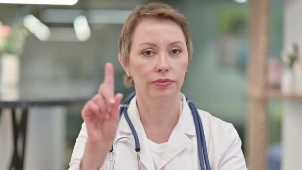 Middle Aged Female Doctor Saying No with Finger Sign 