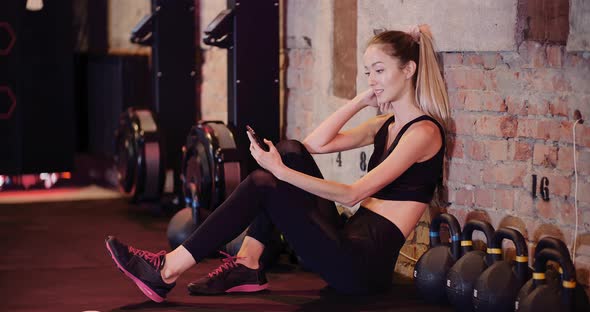 Fit Female Athlete Using Smartphone