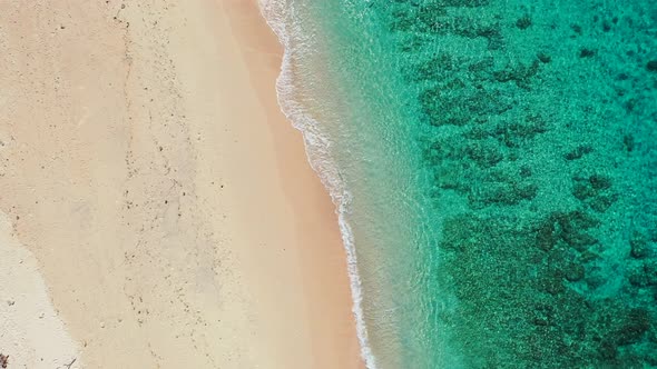 Tropical fly over abstract shot of a white paradise beach and blue water background in vibrant 4K