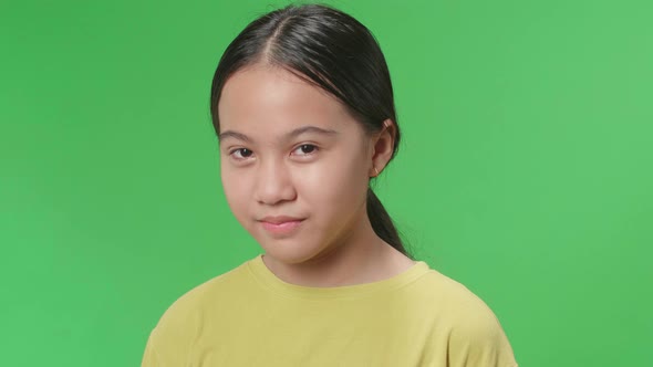 Terrible Asian Kid Girl Looking At Camera In The Green Screen Studio alt