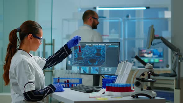 Chemistry Doctor Analysing Blood Sample and Typing on Computer