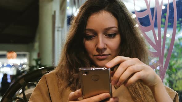 Girl Uses a Smartphone, a Waiter Asks a Question for Order in a Cafe