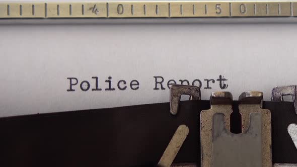 Typing phrase Police Report on retro typewriter. Close up.