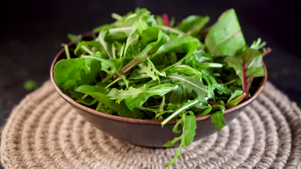 Mix salad greens. Arugula, lettuce, spinach in black bowl Video 4k