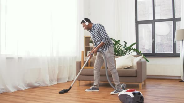 Man in Headphones with Vacuum Cleaner at Home 121