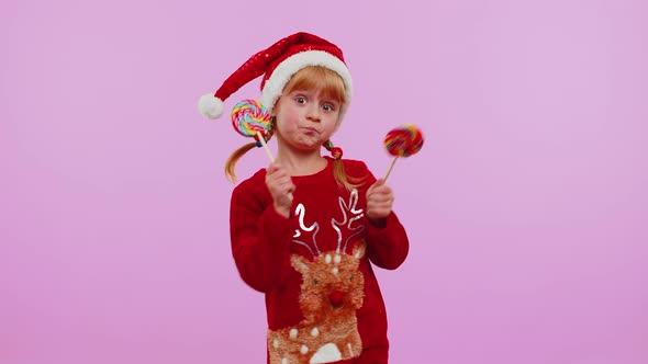 Joyful Girl in Christmas Sweater Hat Holding Candy Striped Lollipops Dancing Making Silly Faces