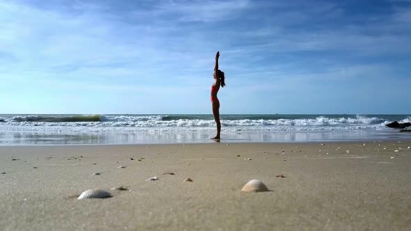 Girl Does Yoga Changing Positions Against Wavesurf