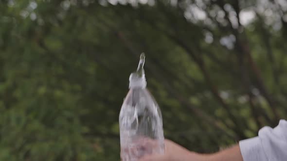 Closeup Slow Motion Water Falling Down From Bottle with Drops Splashing
