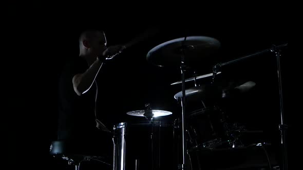 Good Music in the Perfomance of a Professional Drummer. Side View. Black Background. Slow Motion