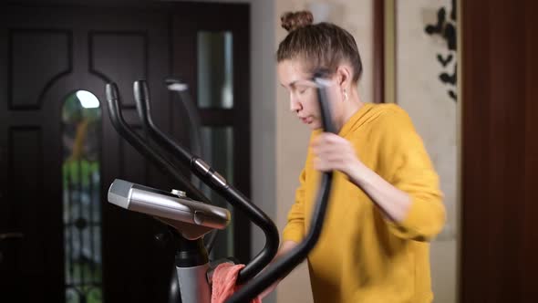 The girl trains, dries sweat with a towel and squeezes a wet towel through