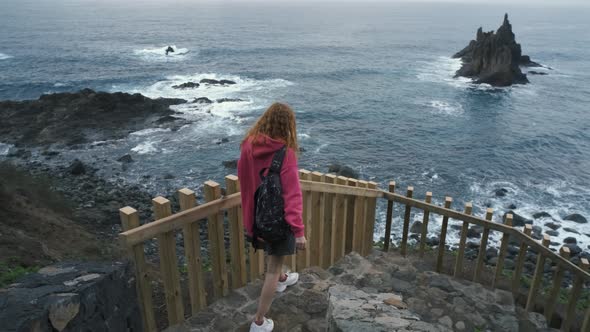 Young Woman Tourist Goes Down the Long Stairs to the Famous Volcanic Black Sand Beach Benijo in the