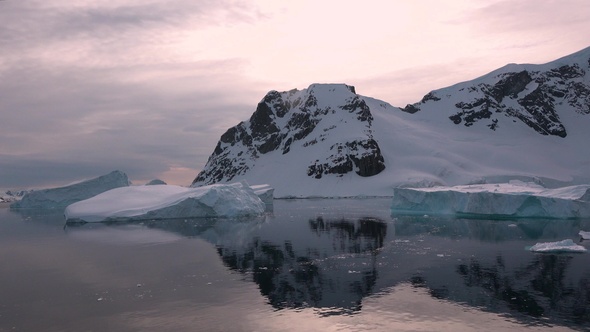 Environment. Reflection of mountains and icebergs in the water. Antarctica. Life of nature.