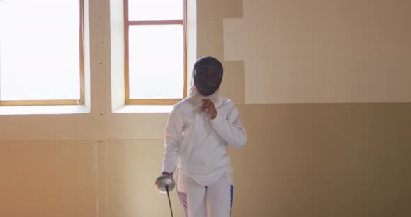 Female fencer athlete during a fencing training in a gym