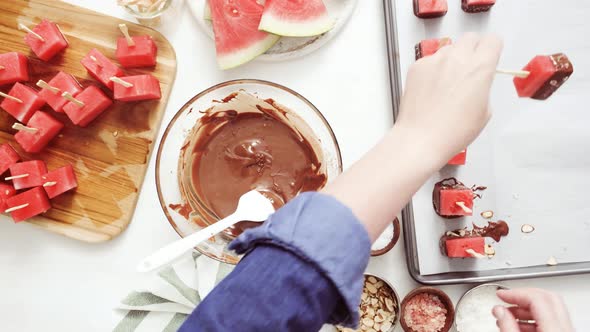 Time lapse. Step by step. Dipping watermelon cubes into melted chocolate and garnishing with sea sal