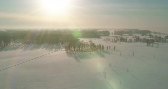 Aerial View of Cold Winter Landscape Arctic Field, Trees Covered with Frost Snow, Ice River and Sun