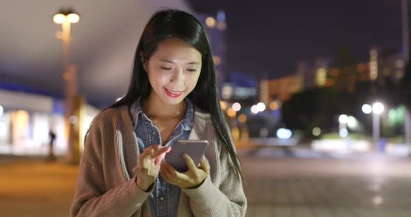 Young Woman Using Mobile Phone at Night