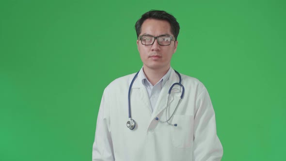 Asian Doctor With Stethoscope Wearing Glasses And White Coat Walking On Green Screen