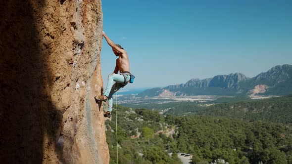 Slow Motion of Athletic Man Climbs an Vertical Rock with Rope Lead Climbing