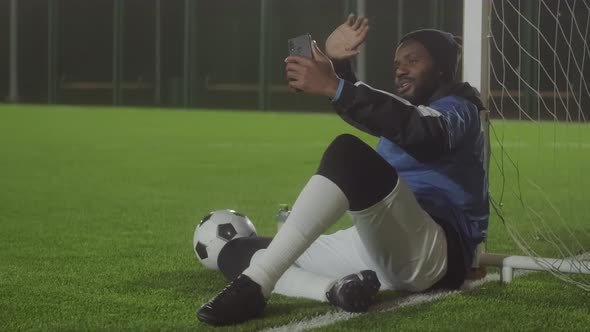 Man Video Calling on Soccer Field