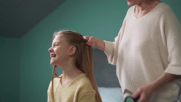 Grandmother braiding her granddaughter's hair