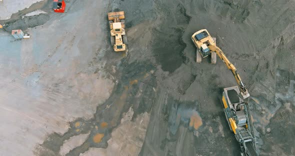 Wheel Frontend Loader Loads Sand Into a Heavy Machinery in the Mobile Jaw Crusher Plant with Belt