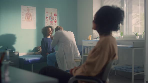 Pediatrician Examining Girl Throat