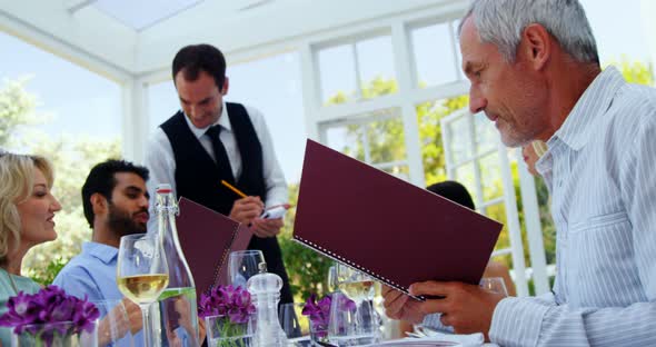 Waiter taking an order from customers