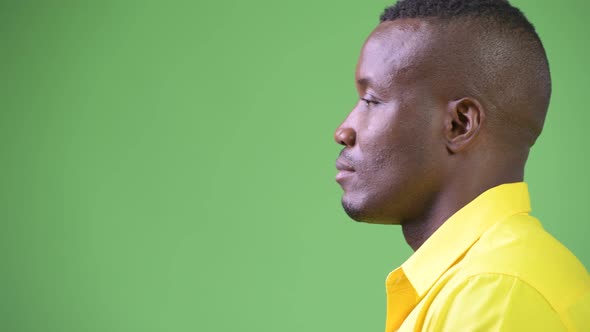 Profile View of Young African Businessman Thinking While Wearing Yellow Shirt