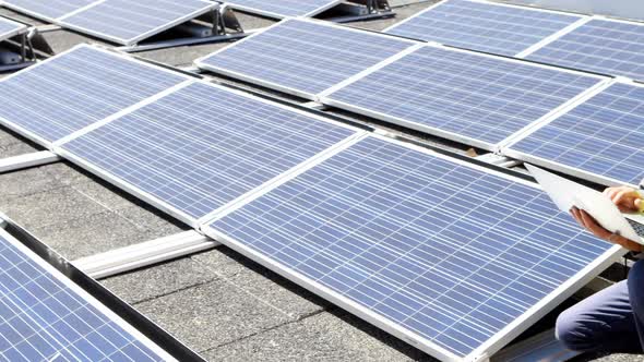 Male worker using laptop at solar station 4k