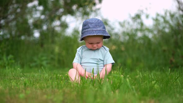 Cute Baby78 Months Old in the Park Sitting on the Grass