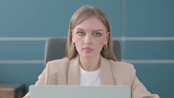 Close Up of Businesswoman Showing Thumbs Down Sign While Using Laptop in Office