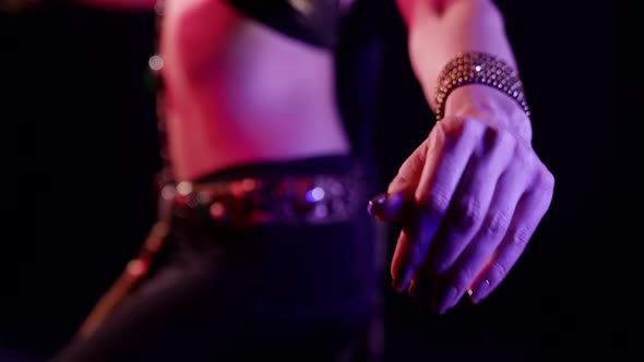 Closeup of a Woman Who Is Dancing an Oriental Belly Dance on a Black Background in the Studio Side