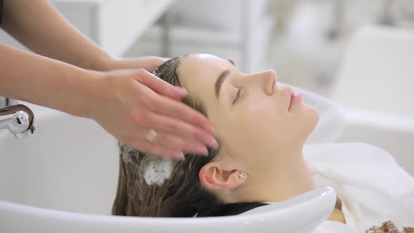 Beauty Concept, Young Woman with Hairdresser Washing Head at Hair Salon