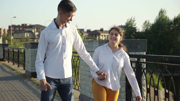 Couple of Young People with Cerebral Palsy Walks on Bridge