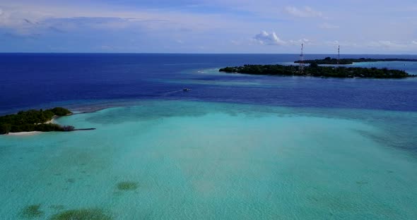 Natural fly over tourism shot of a white sandy paradise beach and aqua blue water background in vibr