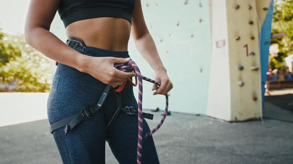 Close Up of Professional Woman Alpinist Tying Knot Out of Climbing Rope