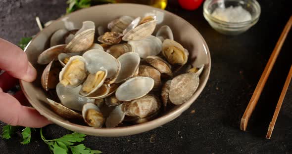 The Man's Hand Puts a Plate with Boiled Mussels Vongole.