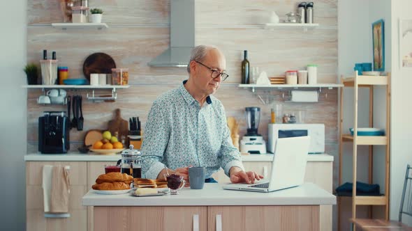 Senior Man Browsing on Laptop