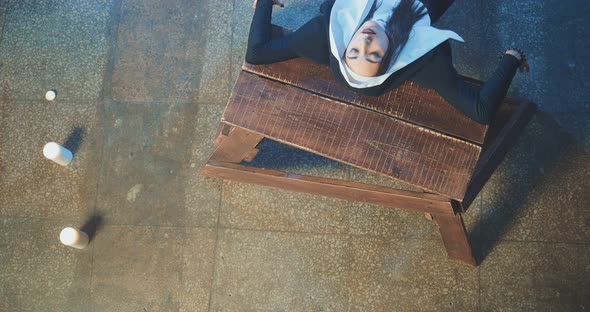 Nun is Posing on Her Back in a Dark Room