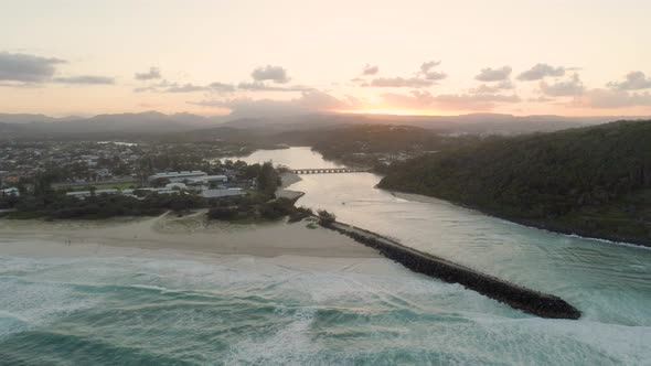 Aerial Descend Over Tallebudgera Creek Mouth Facing the Sun at Sunset